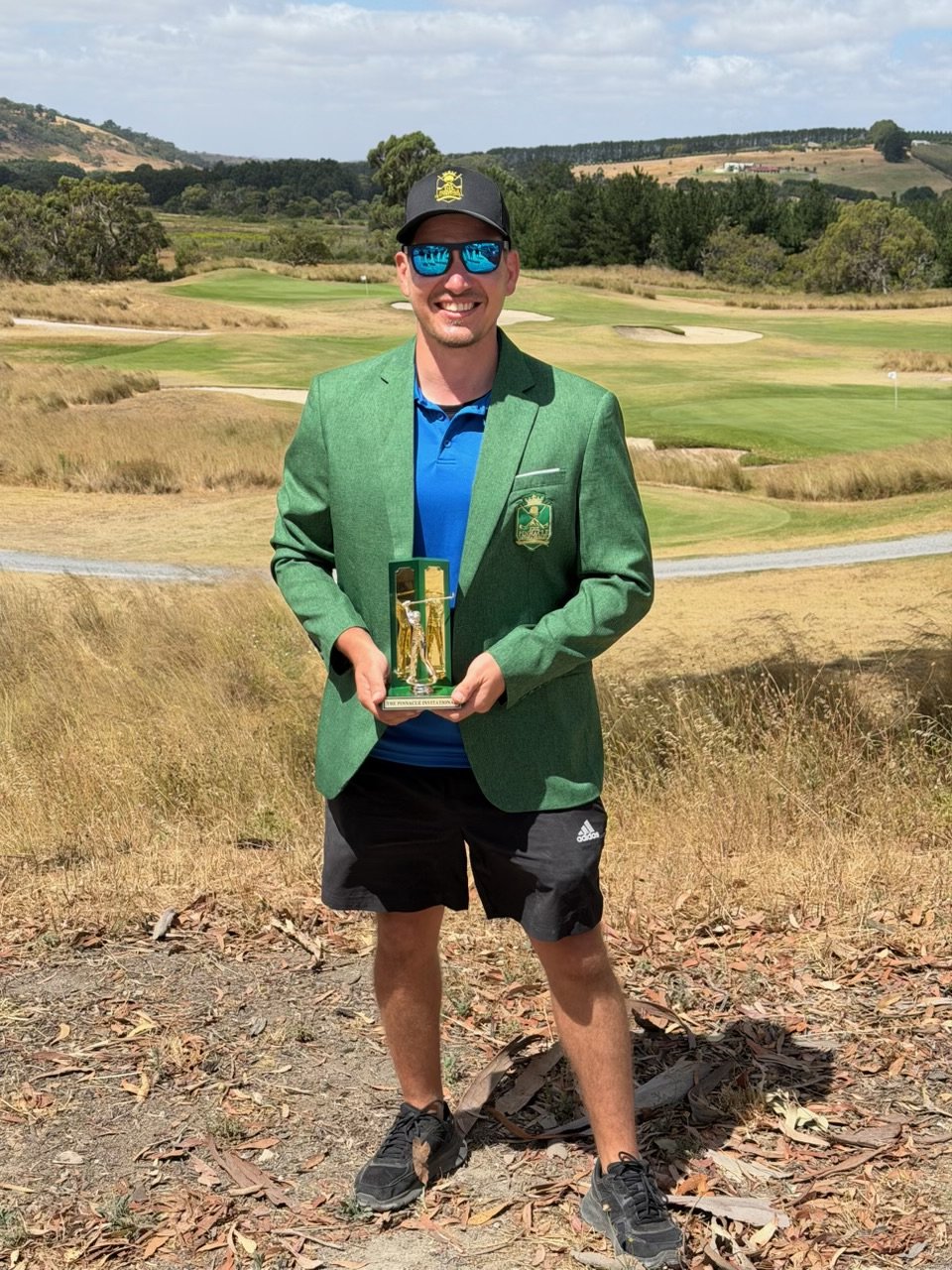Simon Nedelkovski wearing the inaugural Pinnacle Green Jacket and holding the trophy